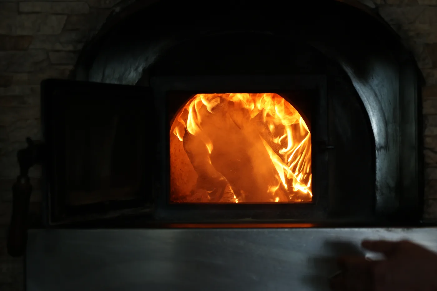 Pizza aus dem Holzofen mit offener Flamme